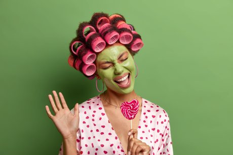 žena sa viklerima na glavi peva